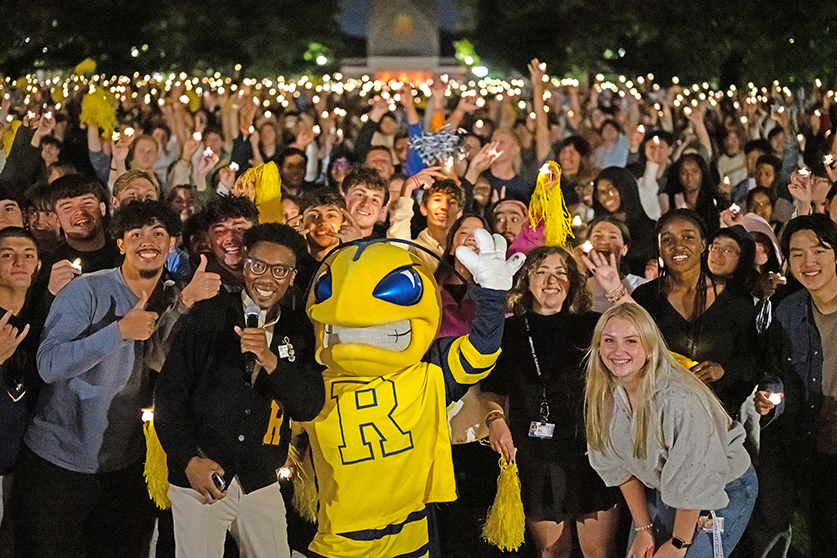 A large group of students and Rocky cheering for the camera.