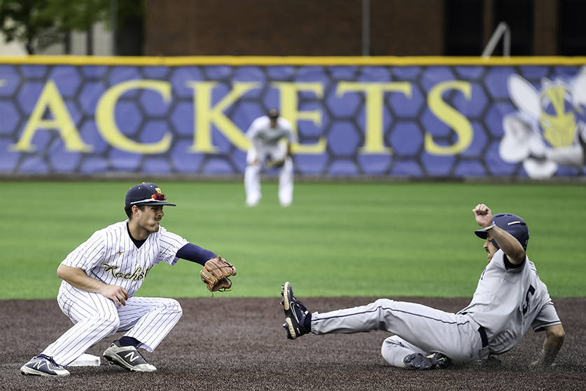 A baseball player sliding into base while another reached for the ball.