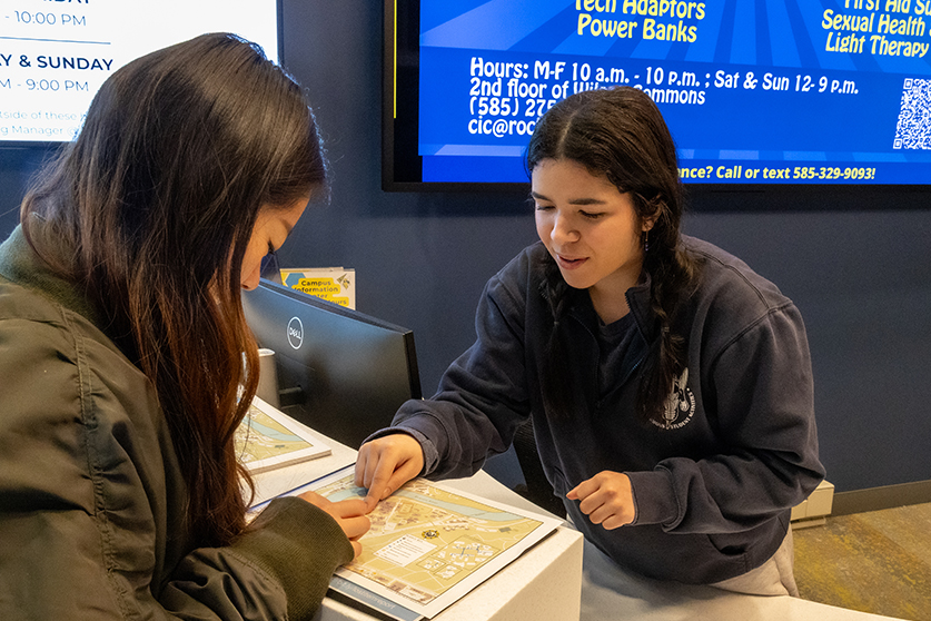 A person giving information from behind a table.