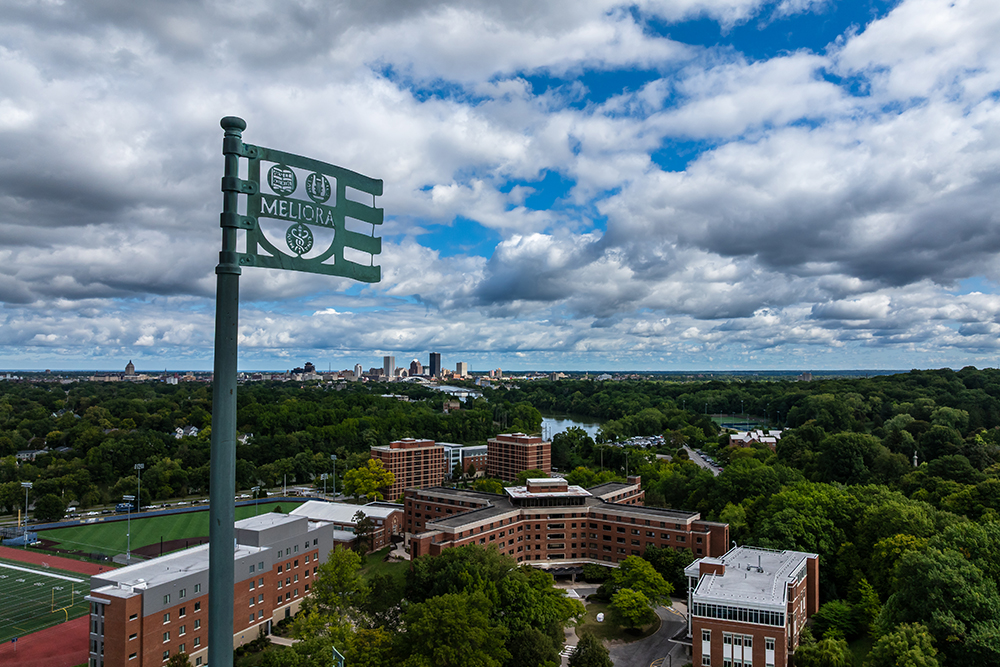 An aerial view of the River Campus with a metal flag in the foreground.